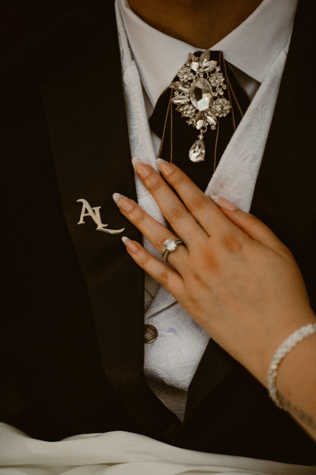 Bride's hand resting on the groom's chest
